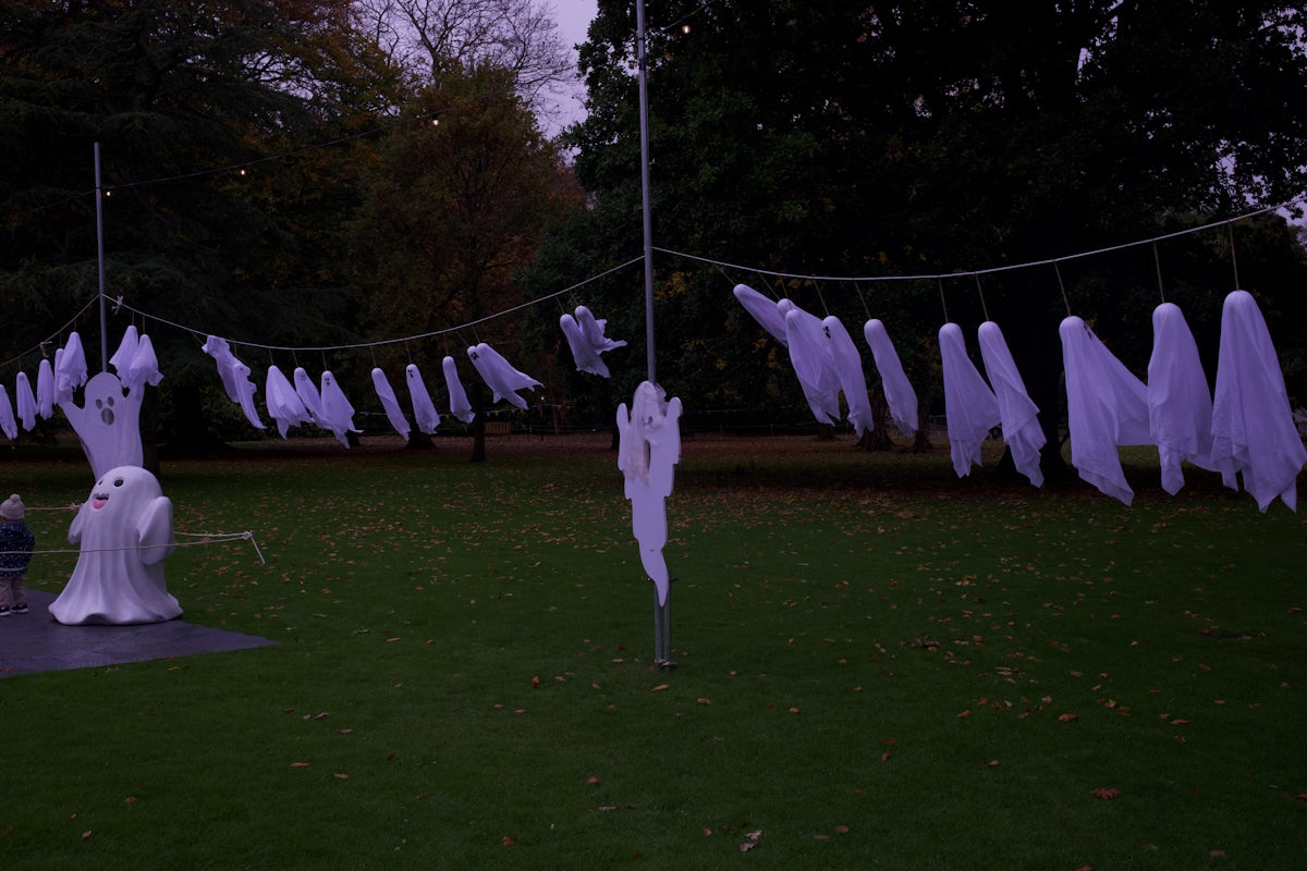 White ghost decorations hanging on a line outdoors